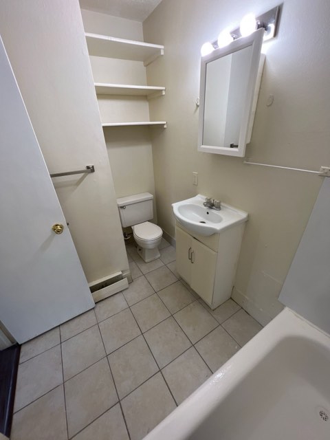 Bathroom with tub and shelving