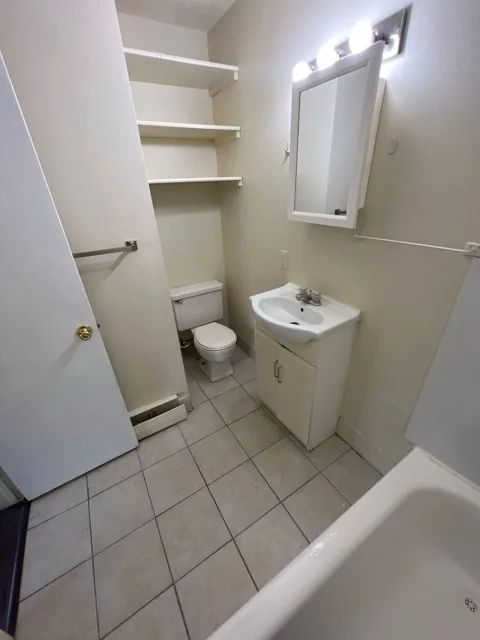 Bathroom with tub and shelving