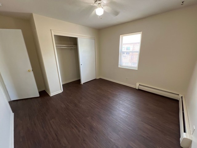 Bedroom with plank flooring and double closets