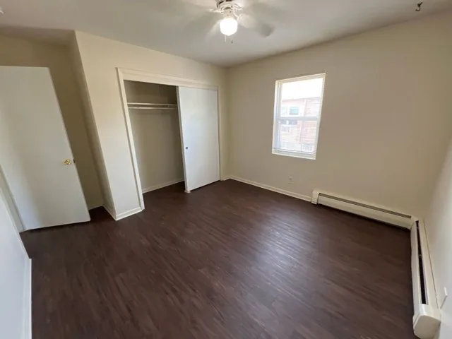 Bedroom with plank flooring and double closets
